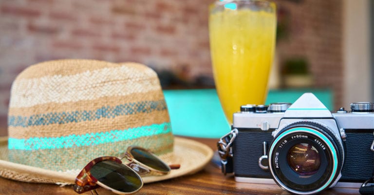 cest les vacances photo avec un chapeau, lunettes de soleil et un appareil photo